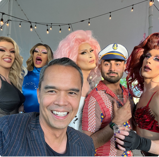 Six people posing for a selfie with string lights in the background.